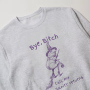 A grey sweatshirt with a purple illustration of a frog wearing a witch's hat and holding a broom, along with the text 