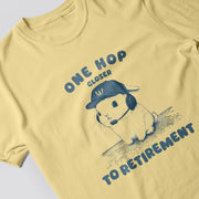 A yellow t-shirt with a graphic design featuring a cartoon rabbit wearing a baseball cap and the text 