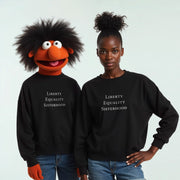 Two people wearing black sweatshirts with the text 