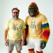 Two men wearing yellow t-shirts with a graphic of a man's face and the text 