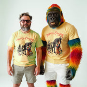 Two men wearing matching yellow t-shirts with a Christmas-themed graphic and text, standing next to each other.