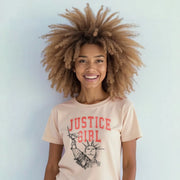 A smiling woman with curly hair wearing a t-shirt with the text 