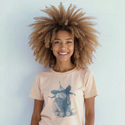 A smiling woman with curly hair wearing a t-shirt with a rabbit graphic.
