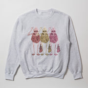 A gray sweatshirt with a graphic design featuring three stylized human figures in a line, each holding a bag and wearing sunglasses.