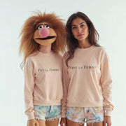 Two women wearing matching pink sweatshirts with the text 
