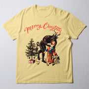 A yellow t-shirt with a Christmas-themed graphic design featuring a large, menacing creature, a Christmas tree, and two people.