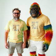 Two men wearing matching yellow t-shirts with a graphic design stand next to each other.