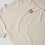 A cream-colored t-shirt with a small graphic design on the front, depicting a pair of ice cream cones.
