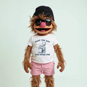 A cartoon character with long brown hair, wearing a black beanie, sunglasses, and a white t-shirt with a graphic and text.