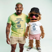 A man in a yellow t-shirt and shorts stands next to a large, furry mascot wearing a white t-shirt and pink shorts, both smiling and posing together.