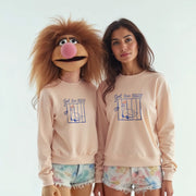 Two women wearing matching pink sweatshirts with a cartoon character on them, posing together.