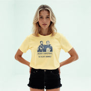 A woman wearing a yellow t-shirt with a graphic design featuring two men and the text 