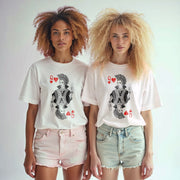Two young women wearing white t-shirts with a graphic design of a queen of hearts and a queen of spades on them.