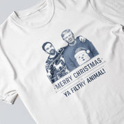 A white t-shirt with a graphic design featuring two men wearing Santa Claus sweaters and the text 