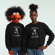 Two people wearing black sweatshirts with the text 