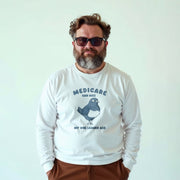 A man wearing a white long-sleeved shirt with a humorous political message printed on it.