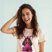 A smiling woman with long brown hair wearing a white t-shirt with a graphic design of a purple character with horns.