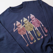 A navy blue sweatshirt with a colorful graphic design depicting three stylized women in pink dresses.
