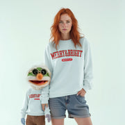 A woman with red hair wearing a white sweatshirt with the text 