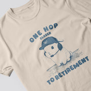 a t-shirt with a graphic design depicting a rabbit wearing a baseball cap and the text 