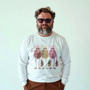 A man wearing a white long-sleeved shirt with a graphic design of three cartoon-like figures holding bags and standing together.