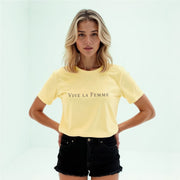 A young woman with blonde hair wearing a yellow t-shirt with the text 