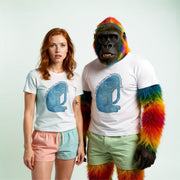 A woman wearing a white t-shirt with a blue elephant graphic and pink shorts stands next to a man wearing a white t-shirt with a colorful elephant graphic and green shorts.