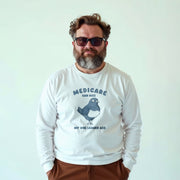 A man wearing a white long-sleeved shirt with a humorous political message printed on it.