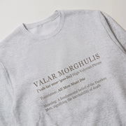 A gray sweatshirt with the definition of 'Valar Mor' printed on it.