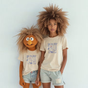 Two people wearing matching t-shirts with a cartoon character design stand together against a white background.