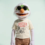 A white and green plush toy wearing a yellow t-shirt with the text 
