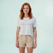 A woman with red hair wearing a white t-shirt with the text 
