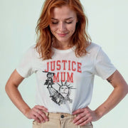 A woman with red hair wearing a white t-shirt with a graphic design and text printed on it.