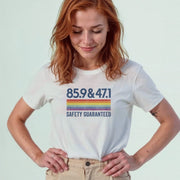 A woman with red hair wearing a white t-shirt with a graphic design and text printed on it.