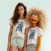 A woman wearing a white t-shirt with a graphic and a man wearing a white t-shirt with a graphic, both smiling and posing together.