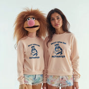 Two women wearing matching pink sweatshirts with a cartoon raccoon and the text 