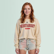 A young woman with red hair wearing a beige sweater with the text 