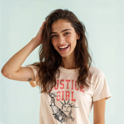 A smiling woman with long brown hair wearing a white t-shirt with a graphic design.