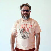 A man with a beard wearing a t-shirt with a graphic design and text printed on it.