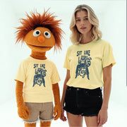 a person wearing a yellow t-shirt with a graphic of a cartoon character and the text 