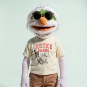 A white and green plush toy wearing a yellow t-shirt with the text 